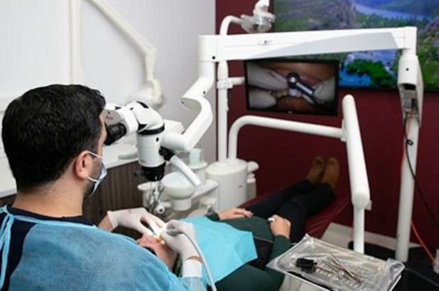 Endodontist working through a dental operating microscope